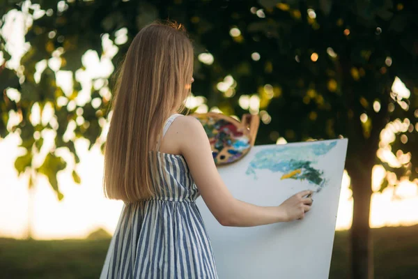 Rückseite der blonden Haare Mädchen im Kleid Zeichnung eines Bildes im Park — Stockfoto