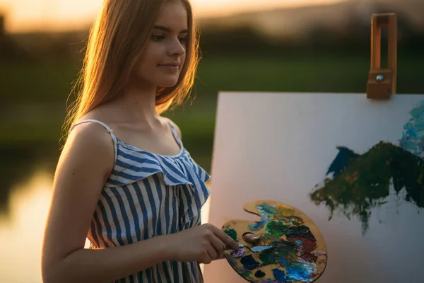 Portret van mooie blonde haar meisje trekt foto door de rivier — Stockfoto