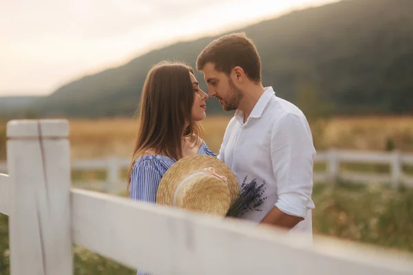 MA a jeho těhotná manželka stojí v poli poblíž farmy a obejmout — Stock fotografie