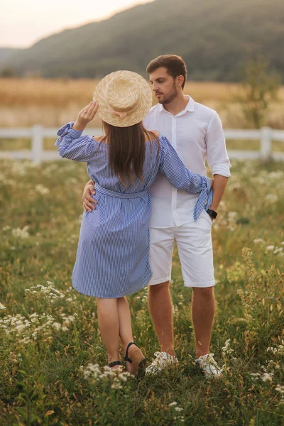 Mann und schwangere Frau stehen auf Feld in der Nähe des Hofes und umarmen sich — Stockfoto
