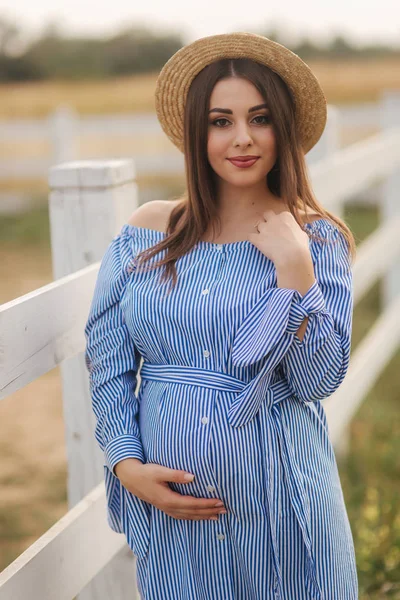 Beau portrait de femme enceinte gaie en robe bleue et chapeau tricoté. Dame sourire — Photo