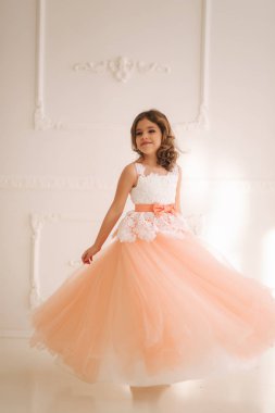 Güzel elbiseli mutlu küçük prenses olsa büyük stüdyo yürüyüş. etrafında spin