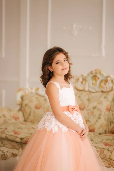 Счастливая маленькая принцесса в красивом платье ходить хотя большая студия — стоковое фото