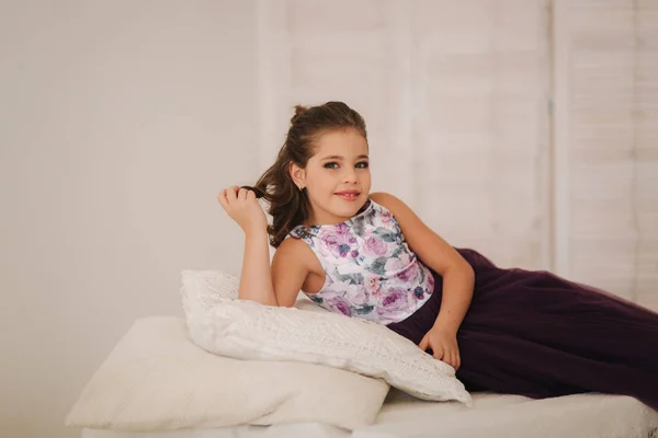 Μικρό κορίτσι sist σε έναν καναπέ. Ευτυχισμένο παιδί σε stodio. Μικρό μοντέλο — Φωτογραφία Αρχείου