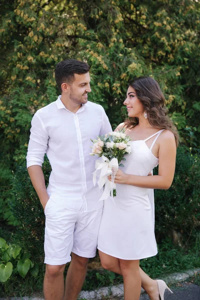 Beau couple en blanc. Futur marié et fiancée. bouquet de fleurs — Photo