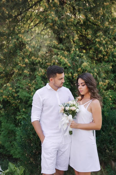 Mooie paar in wit. Toekomstige bruid en bruidegom. boeket bloemen — Stockfoto