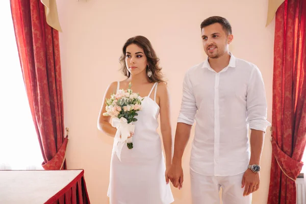 Наречений і наречена стоять всередині шлюбного дому. Красива пара в білому — стокове фото