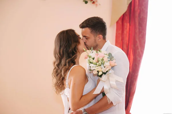 Sposo e sposa in piedi all'interno della casa del matrimonio. Bella coppia in bianco — Foto Stock
