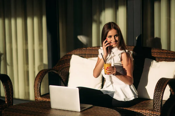 Young beautiful woman use a laptop during a break at work. Summer sunny day — Stockfoto