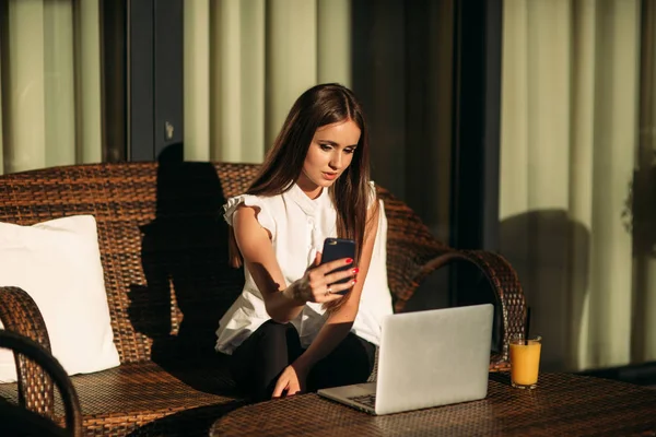 Affärskvinna använder laptop och telefon för arbete. Vackra kvinnliga sitter utanför och arbetar. Färsk apelsinjuice — Stockfoto