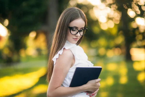 Portré fiatal női tanár tabletta kívül. Modern tanár a parkban. Szemüvegek visel — Stock Fotó