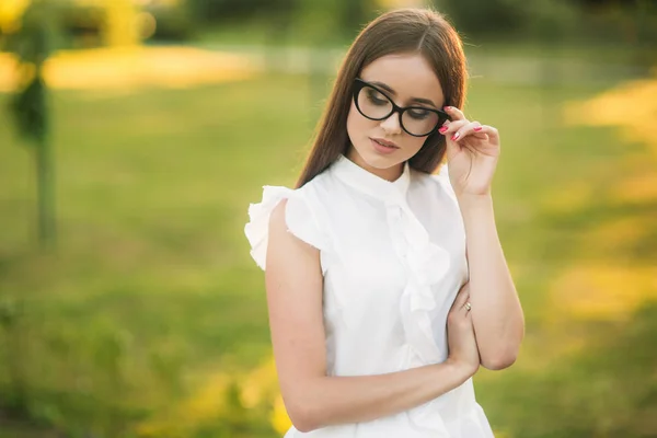 Elegante Frau mit Brille, die im Park steht und durch eine Brille schaut. weibliches Modell — Stockfoto