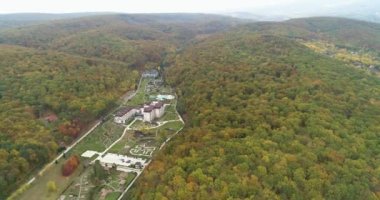 Manzaranın copter görünümü. Orman ve dağlarla çevrili binalar. Doğa parkları