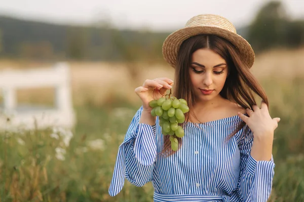 Hermosa mujer embarazada mostrar y comer uvas verdes. Comida saludable. Frutas frescas. Mujer feliz sonrisa — Foto de Stock