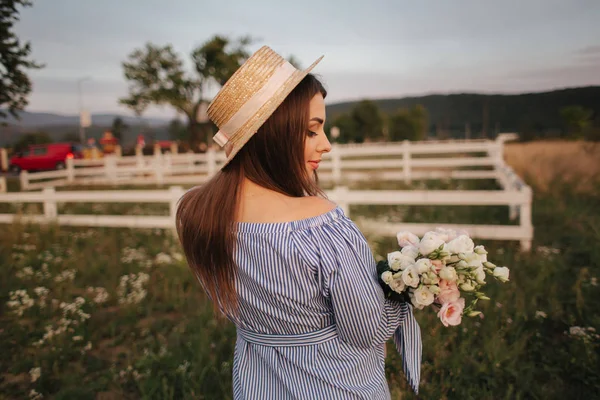 Vue arrière de Belle dame. Elle tient un bouquet de fleurs et sourit. Contexte de l'exploitation — Photo