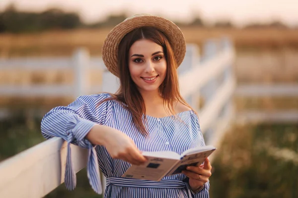 Hermosa mujer embarazada leyó el libro en la granja. Ella está al lado de la novia y mira el libro. Relájate. — Foto de Stock