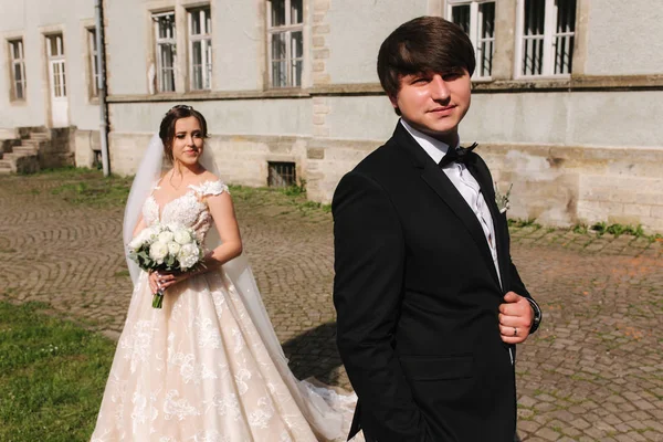 Nygifta står framför slottet. Brudgummen och bruden — Stockfoto