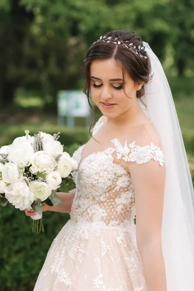 Красивая невеста в свадебном платье прогулка по парку — стоковое фото