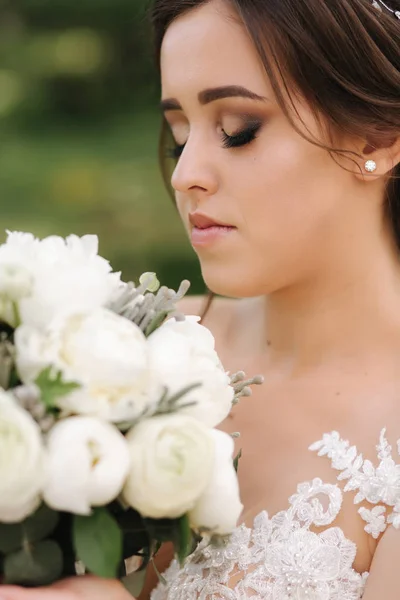 Nahaufnahme Porträt der wunderschönen Braut mit Blumenstrauß — Stockfoto