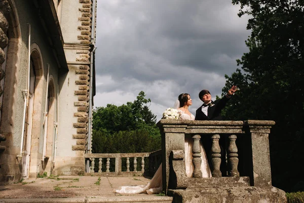 Жених и невеста стоят на балконе у замка — стоковое фото