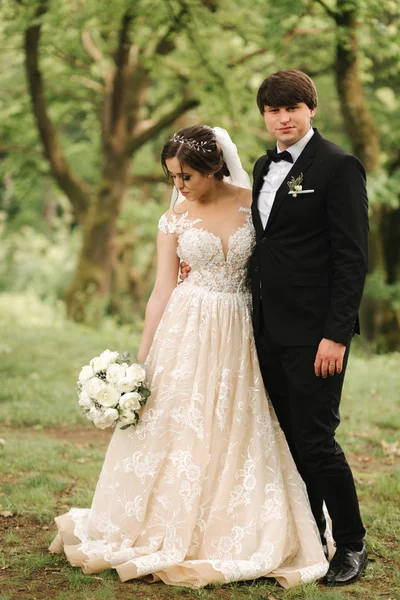 Bara gifta coupleon grön bakgrund, kvast och bruden går i skogen — Stockfoto