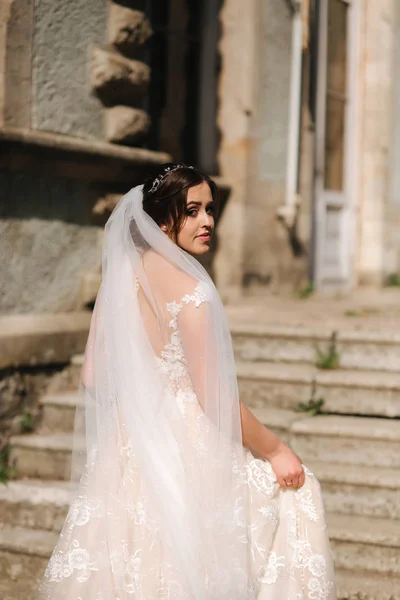 Krásná nevěsta v elegantní svatební šichtě nahoru po schodech. Velké vlakové pustky — Stock fotografie