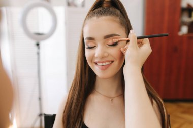 Model güzellik salonunda makyaj sanatçısı tarafından bir makyaj var. İlk kişi görünümü. Çilli Kızıl saçlı model. Makyaj ile modelleri yüz yakın