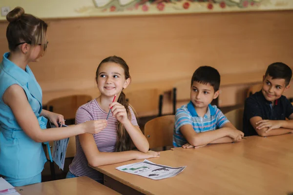 Öğretmenler sınıfta öğrencilerin yazma sınavına yardım ediyor. eğitim, ilkokul, öğrenim ve insanlar konsepti — Stok fotoğraf