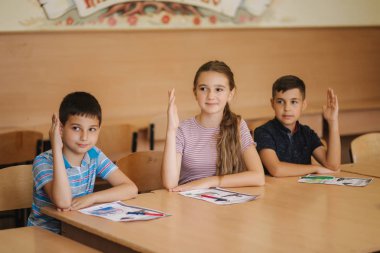 Sınıfta kalem ve defter yazan bir grup okul çocuğu. eğitim, ilkokul, öğrenme ve insan kavramı