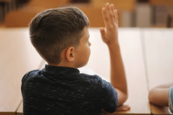 Schoolboy stiger hand i klassrummet. Grundskolan. Utbildning — Stockfoto