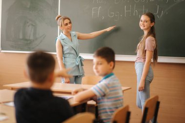 Sınıfta kalem ve defter yazan bir grup okul çocuğu. eğitim, ilkokul, öğrenme ve insan kavramı