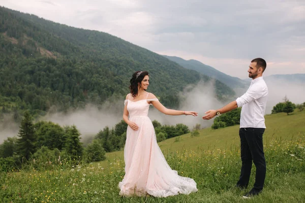 Beau jeune couple de mariage debout sur la pente verte, colline. Mariée et fiancée dans les Carpates — Photo