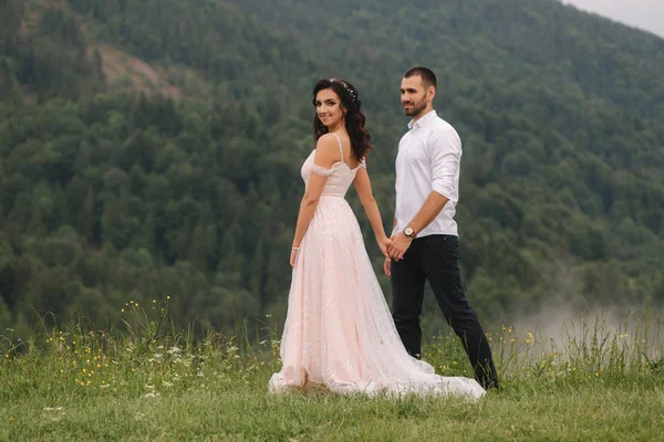 Noivo e noiva walkin thougt as montanhas carpatian — Fotografia de Stock
