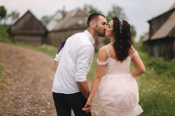 O noivo beija a sua linda noiva. Casal caminhando nas montanhas — Fotografia de Stock