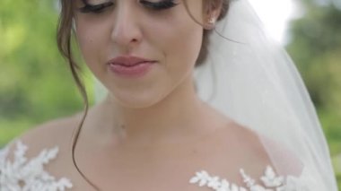 Muhteşem gelinlik Büyüleyici gelin tutun buket ve çiçek açan ağaçların önünde durmak