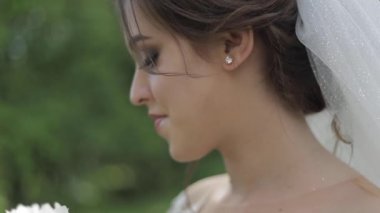 Muhteşem gelinlik Büyüleyici gelin tutun buket ve çiçek açan ağaçların önünde durmak