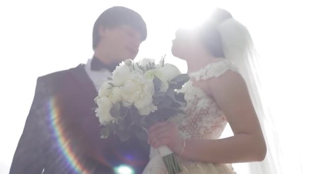 Elega nevěsta v krásných bílých svatebních šatech s hezkou ženichem v parku. Zelené pozadí — Stock video