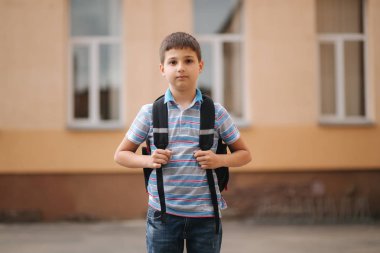 Cute little boy with backpack go home after scholl class clipart