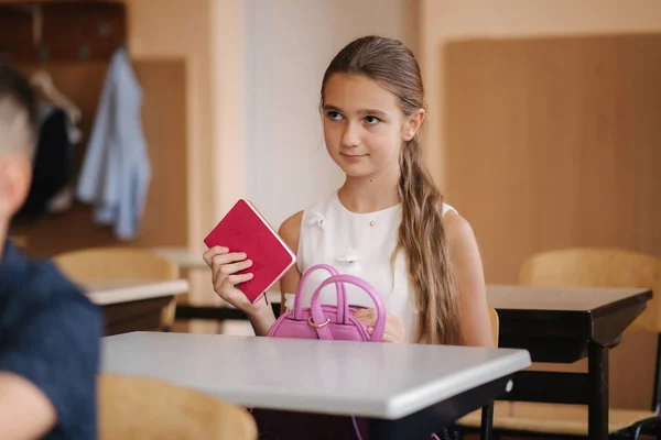 Öğrenci kız bir defter al ve ödevlerini yaz. — Stok fotoğraf