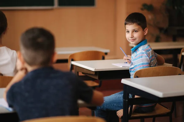 Aranyos fiú lool arround az osztályban szobában. A fiúk hátnézete — Stock Fotó