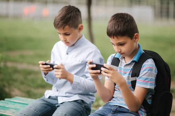 Two boys plays online games in quarantine. Young boys smile and use phone.  One look how play another Stock Photo - Alamy