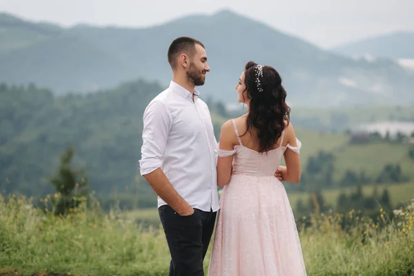 Schönes Hochzeitspaar in den Karpaten. schöner Mann mit attraktiver Frau — Stockfoto