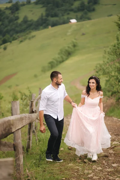 Beau jeune couple de mariage debout sur la pente verte, colline. Mariée et fiancée dans les Carpates — Photo