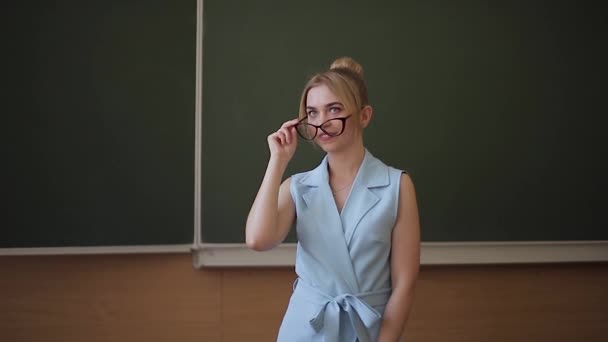 Aantrekkelijke vrouwelijke leraar staan in de voorkant van groene Scholl Desk — Stockvideo