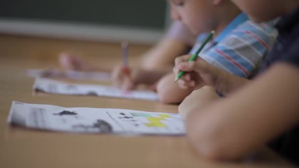 Leraar helpt schoolkinderen met het schrijven van toetsen in de klas. onderwijs, basisschool, leren en mensen concept — Stockvideo