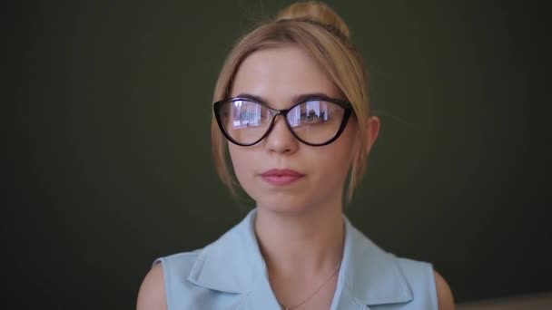 Привлекательная учительница стоит перед зеленым столом — стоковое видео
