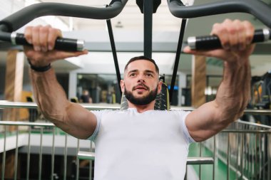 Genç bir atlet spor salonunda eğitiyor. Vücut geliştirmeci göğüs muscules trenler