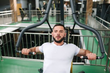 Genç bir atlet spor salonunda eğitiyor. Vücut geliştirmeci göğüs muscules trenler