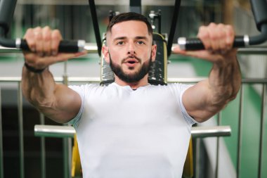Genç bir atlet spor salonunda eğitiyor. Vücut geliştirmeci göğüs muscules trenler