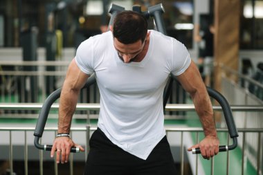 Genç bir atlet spor salonunda eğitiyor. Vücut geliştirmeci göğüs muscules trenler